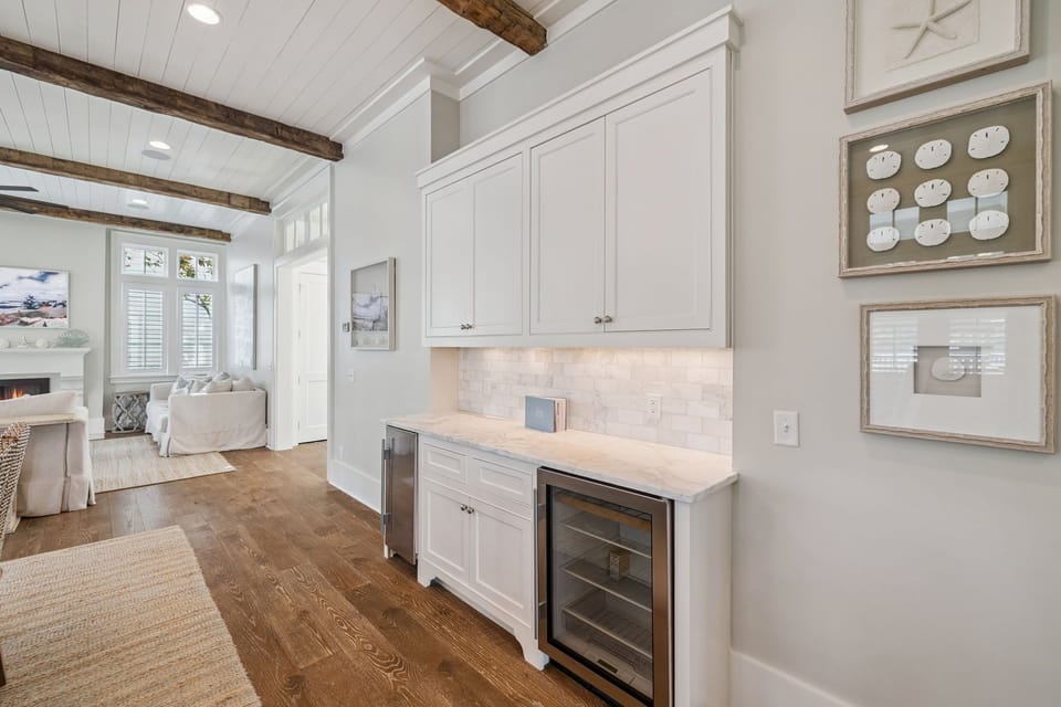 Your elegant butler's pantry features pristine white cabinetry and wine storage, perfect for entertaining guests in coastal style.