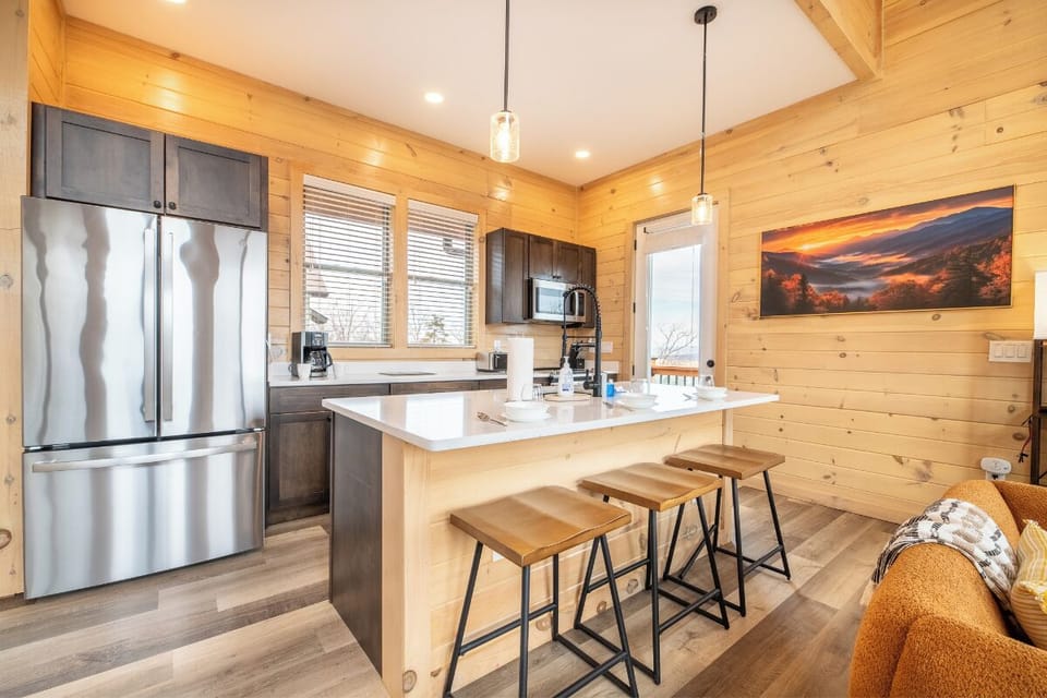 Your gourmet kitchen features stainless appliances and a breakfast bar where you'll savor morning coffee surrounded by warm wood accents.
