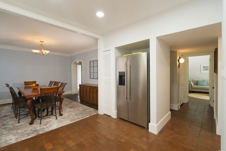 A stylish table for eight with a gleaming stainless steel fridge ready for all your culinary plans.