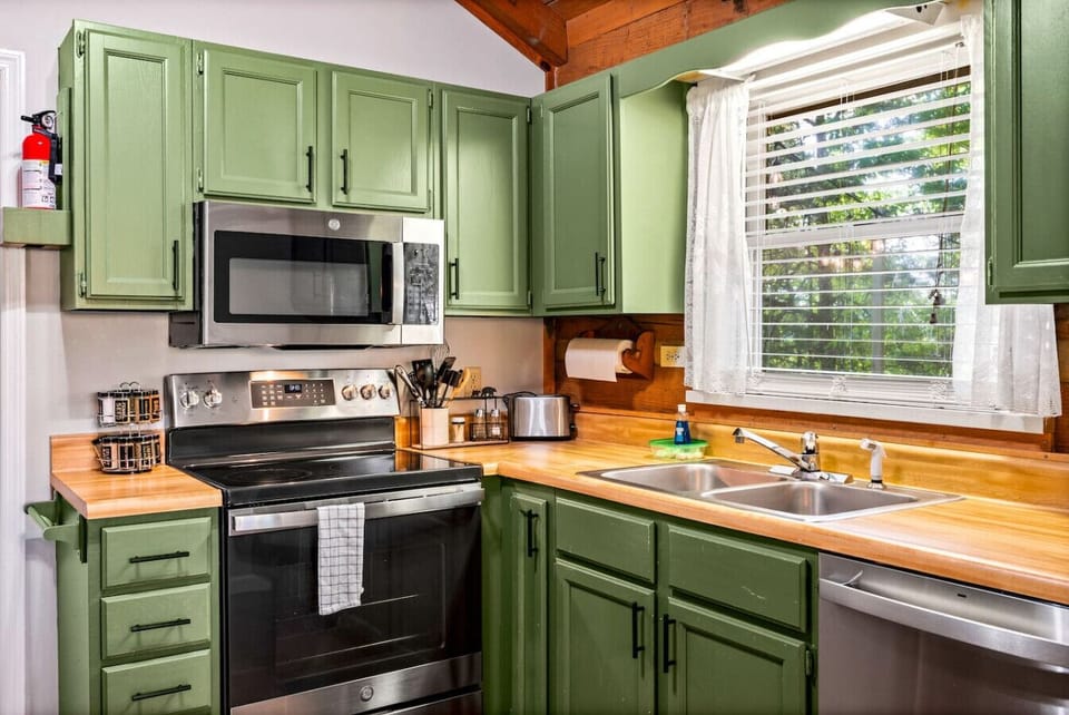 Whip up your favorites in this cheerful kitchen, complete with sage green cabinets, stainless appliances, and all the essentials for a laid-back mountain meal.
