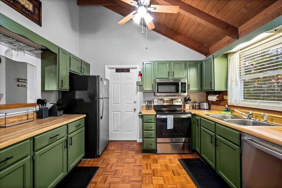 Rustic charm meets homey functionality in this cheerful kitchen, where sage green cabinets and warm wood countertops set the scene for pancake breakfasts, hearty dinners, and late-night snacks with the crew.