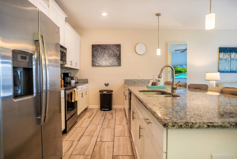 Discover a stylish kitchen with granite countertops and stainless steel appliances, ideal for culinary adventures. The warm lighting and modern decor create a welcoming atmosphere, making it the perfect place to start your day.