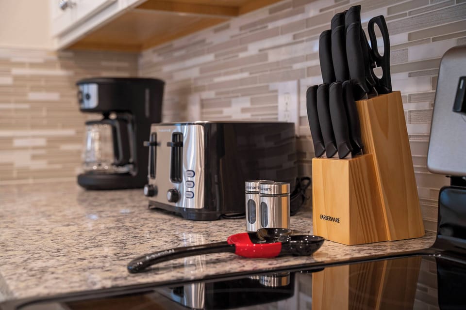 Enjoy the convenience of our well-equipped kitchen with granite countertops and a stylish knife block. Modern appliances like a coffee maker and toaster make meal prep easy in this inviting space.