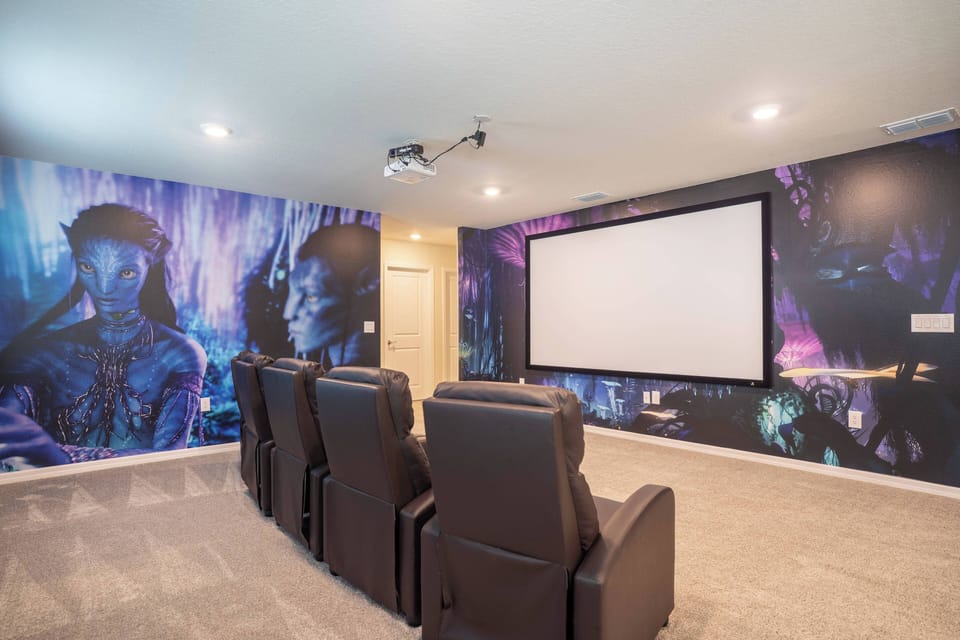 Welcome to the media room, where plush leather recliners invite you to relax. Enjoy vibrant wall art that enhances your movie nights, all while you settle in for an unforgettable experience on the large projection screen.
