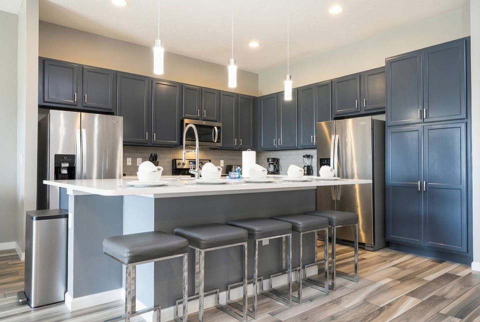 Experience a stylish kitchen featuring elegant navy cabinetry and light countertops, perfectly combining sophistication and practicality.