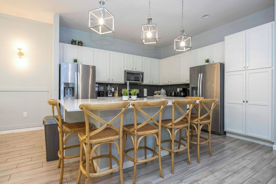 Experience a stylish kitchen with light wood accents and sleek stainless steel appliances, ideal for culinary adventures. The spacious island with inviting bar stools creates a warm atmosphere for gathering and entertaining.