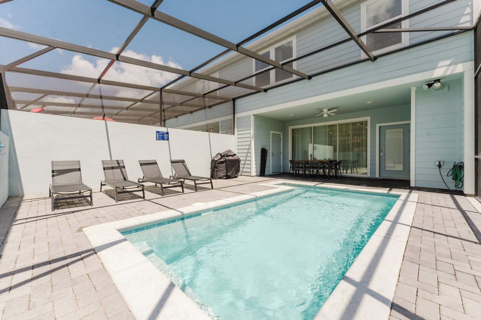 Dive into relaxation with your private pool, surrounded by comfortable loungers and a bright, airy atmosphere. The spacious screened patio invites you to unwind while enjoying the sun-drenched view, perfect for leisurely days.