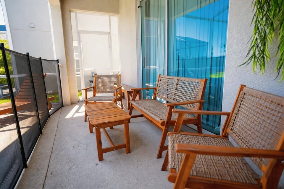 Relax on a covered patio with wooden seating, a small table, and direct access to the pool area. The screened lanai and sliding glass doors create a cozy outdoor spot to enjoy Florida’s sunshine.
