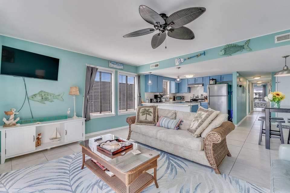 Relax in your coastal-themed living space with ocean breezes from the ceiling fan, comfy seating, and fully equipped kitchen.