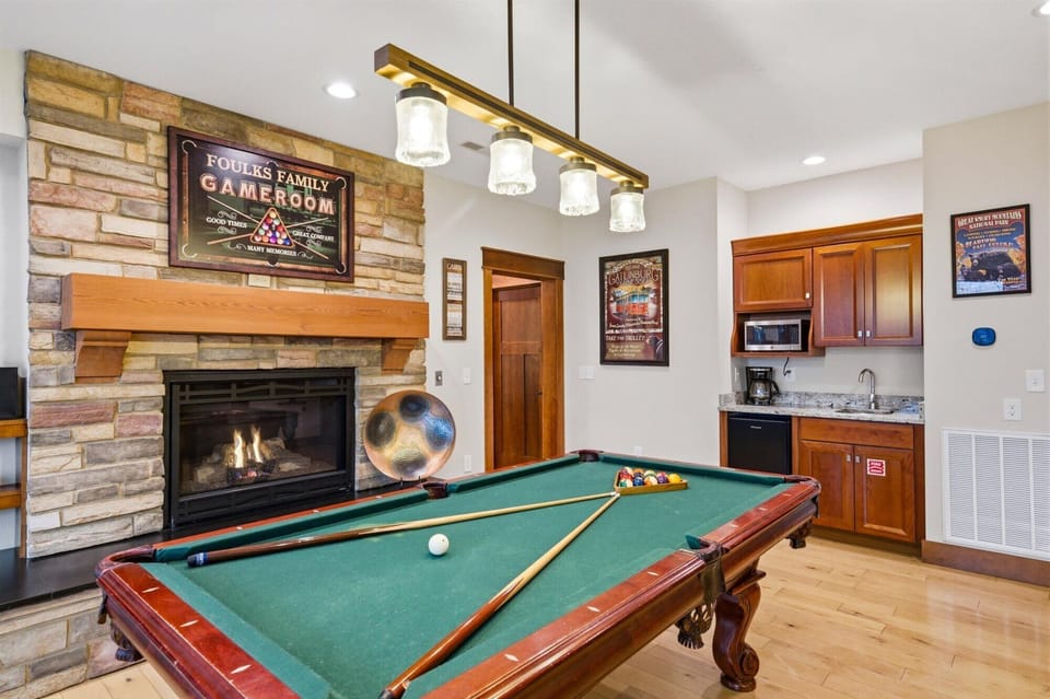 Game room with pool table, gas fireplace and small bar area refrigerator