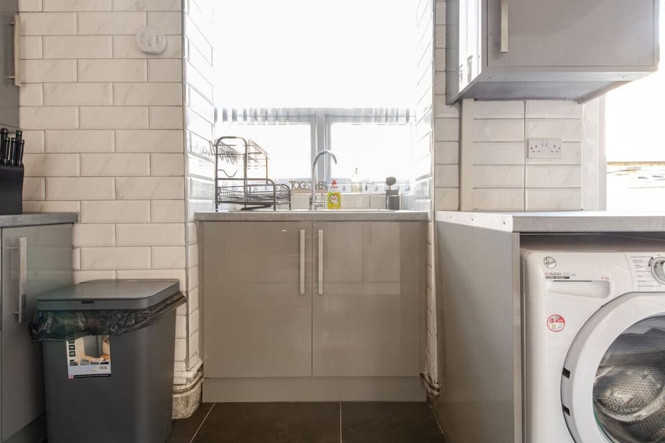Rinse up at the sink with counter space and a window above