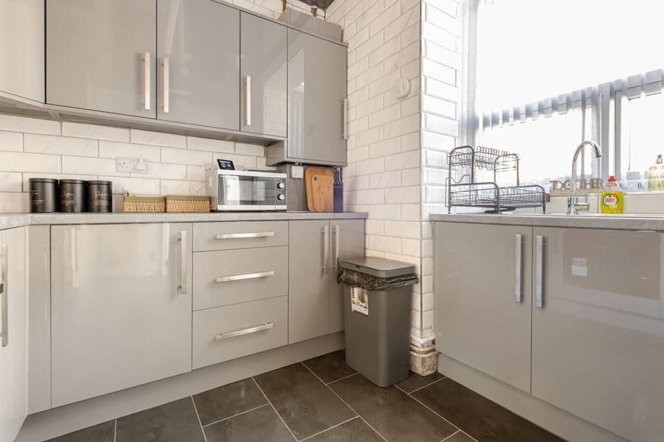 Kitchen corner with cabinets, worktop space, and a dish rack by the sink