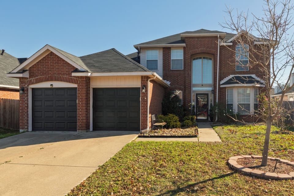 Stunning red brick two-story home with a two-car garage.
