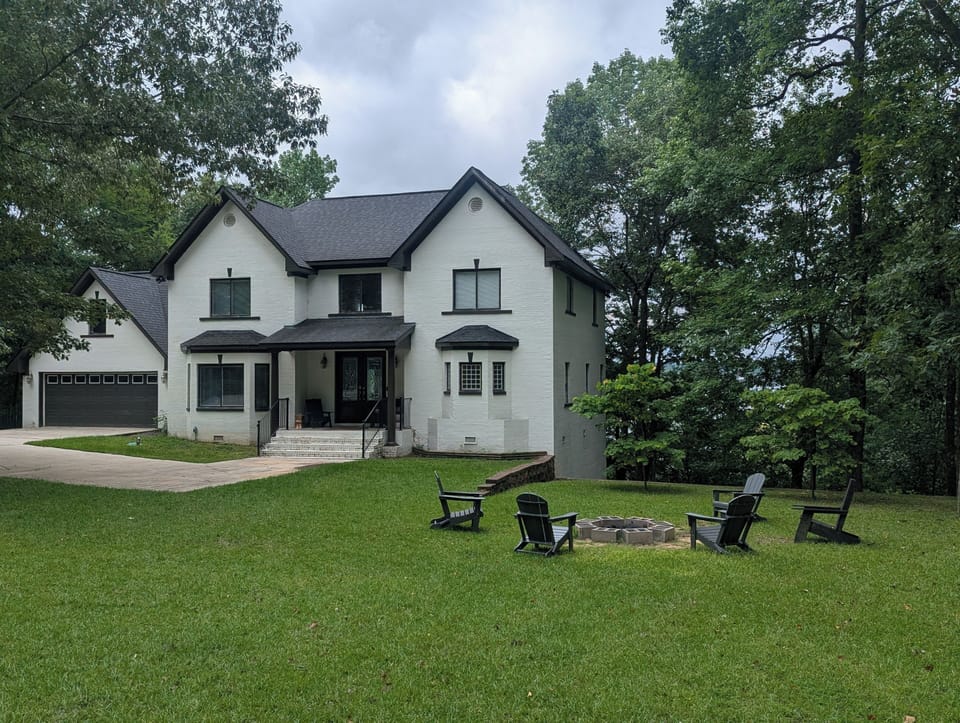 Spacious wooded retreat with large lawn, fire pit, and stylish exterior