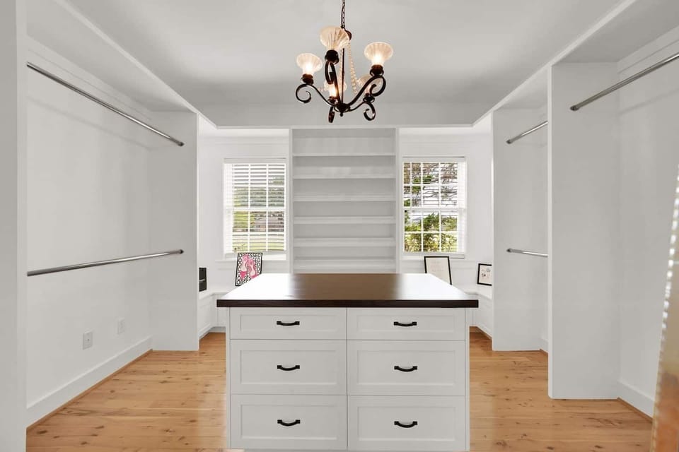 The master bedroom's walk-in closet is accessible from both the bedroom and living room. A Pack 'n Play is conveniently located here for children.