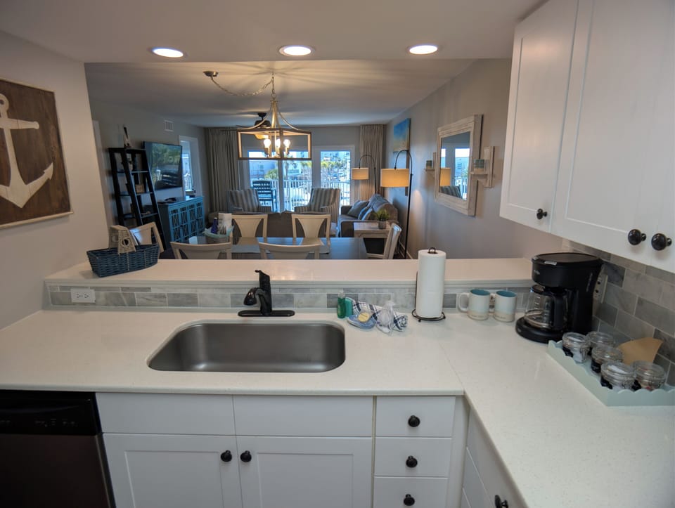 Kitchen view into sitting area, dining area, family room, and slider to balcony.
