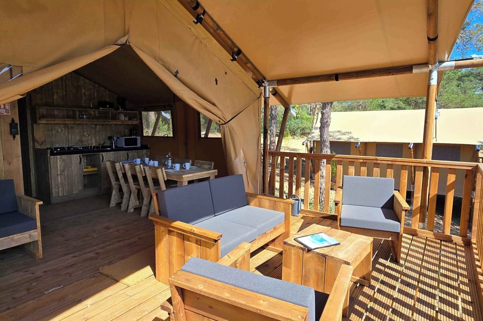 Inside, the wooden terrace invites relaxation with comfortable seating and a cozy dining area, ideal for family meals.