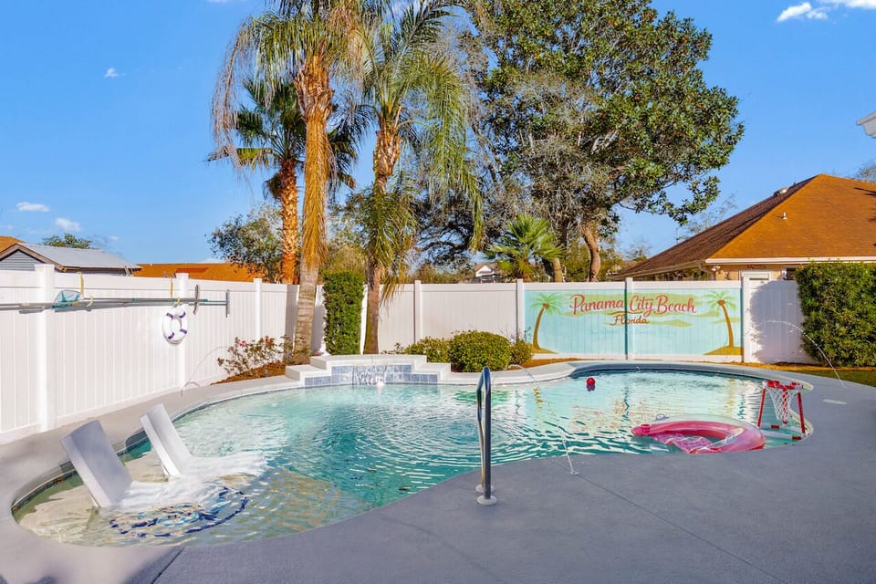 Private PCB pool oasis with sun shelf, spillover spa and palms