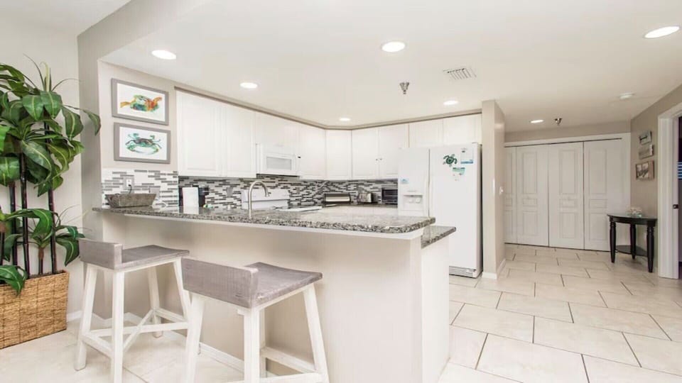 The fully stocked kitchen has beautiful granite counter tops, accented back splash and under cabinet lighting.