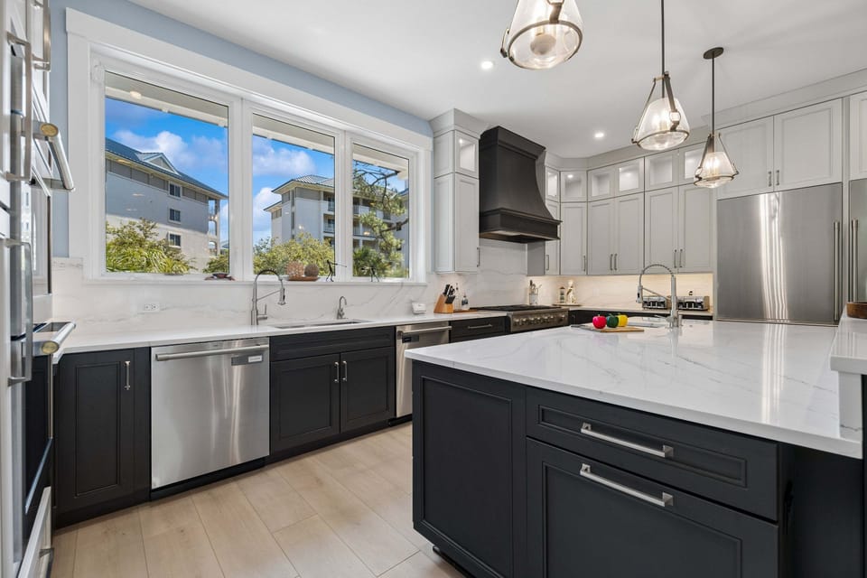 This spacious kitchen features stainless steel appliances, a gas stovetop, restaurant sized fridge, ample countertop space, and multiple beverage fridges!
