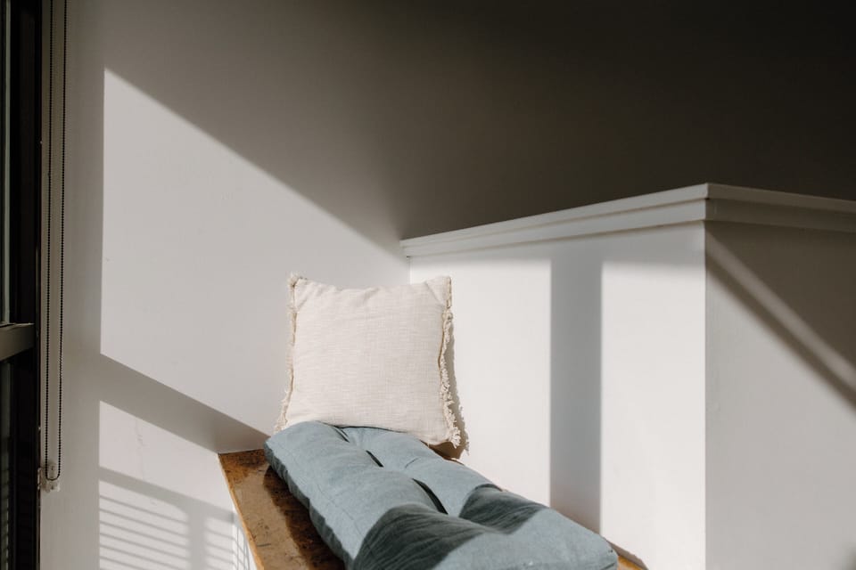 Cozy indoor seating nook near the balcony provides a relaxing retreat with natural light and comfortable lounge space.