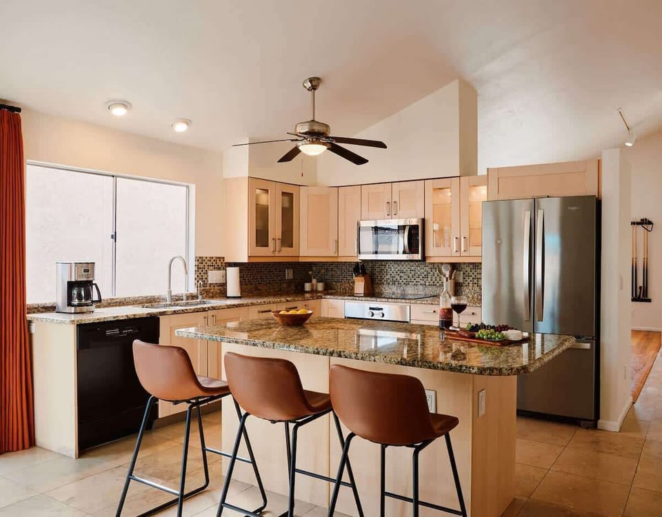 Fully equipped kitchen with stainless steal appliances and a kitchen island with bar seating for 3 guests.