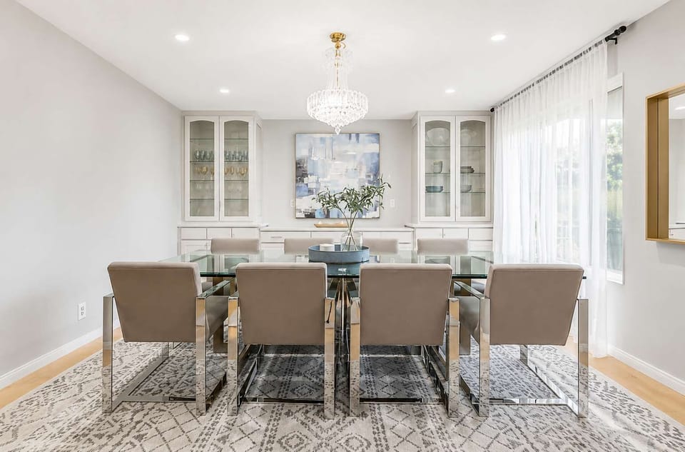 A beautifully designed dining area with 8 comfortable chairs, a sleek modern table, and lighting that adds an inviting warmth to the space