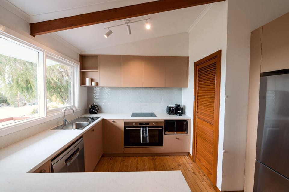 Whip up family favourites in the retro-inspired kitchen, equipped with modern appliances including an oven, dishwasher, and fridge, and designed for shared meals and slow, easy mornings.