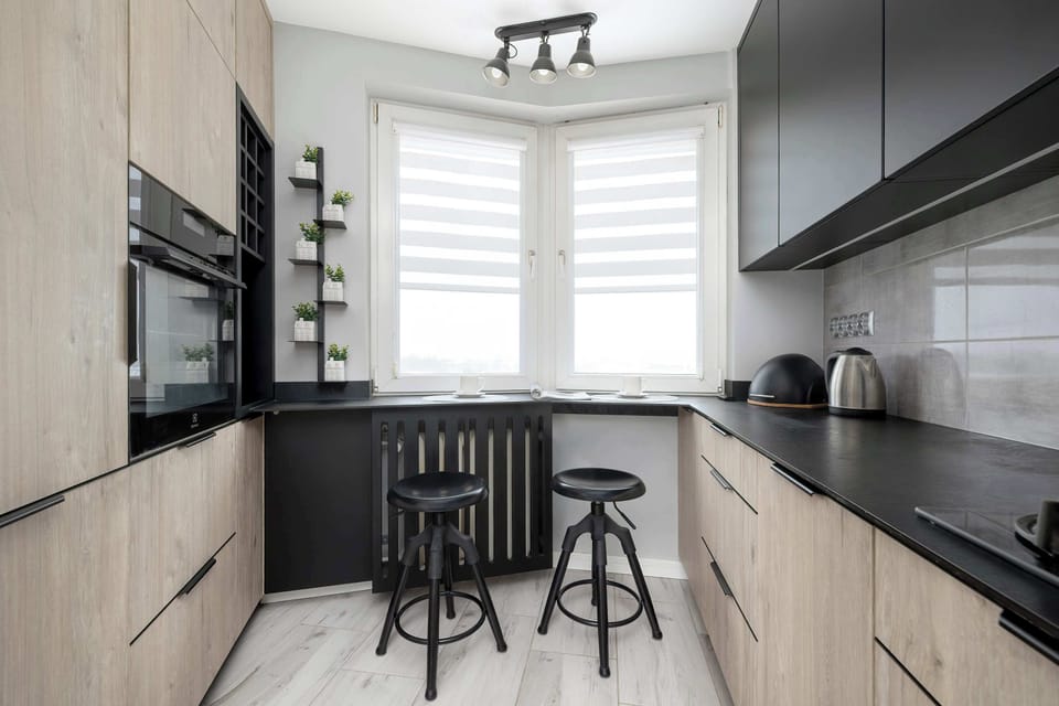 Bright kitchen with modern cabinetry, breakfast bar, and large window.