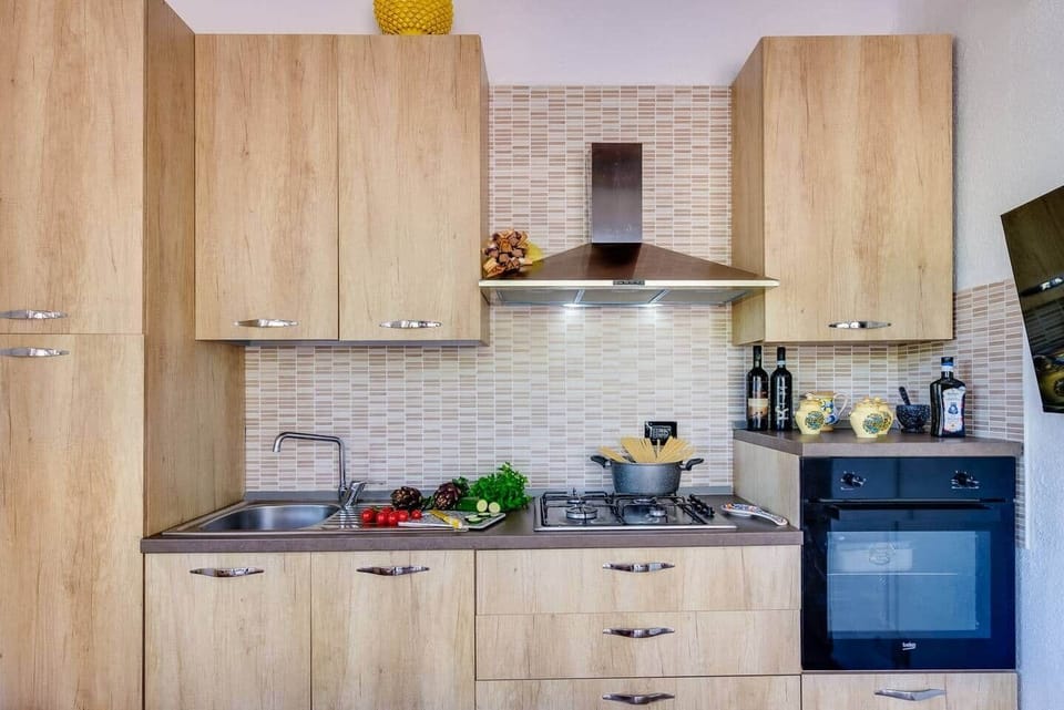 Cucina moderna e funzionale, completamente attrezzata e dallo stile caldo e accogliente. Ideale per preparare comodamente piatti gustosi e autentici con ingredienti locali.