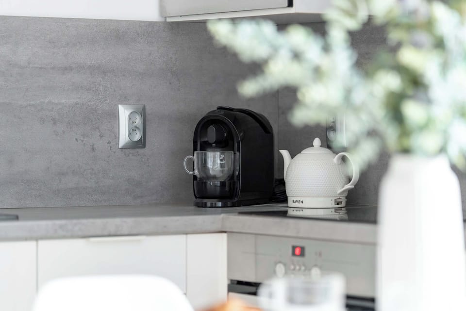 A close-up of a coffee machine and kitchen accessories on the counter. Neutral tones keep the look cohesive. The area feels clean and ready for use.