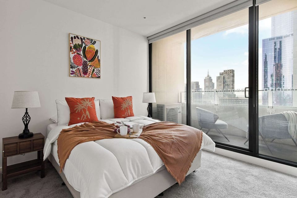 The master bedroom with a queen sized bed & a view over the city. (chairs on balcony are from the living area)