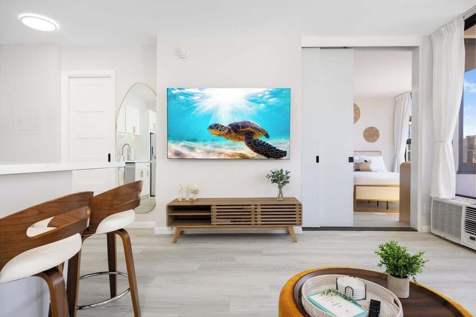 Enjoy watching your favorite movies and tv shows on your 65" smart TV, perfect for your entertainment! The bedroom is separated from the living area by a sliding door.