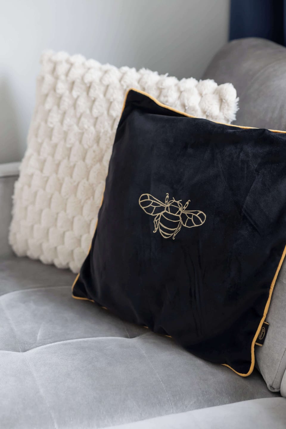 A close-up of decorative pillows arranged on a sofa. The textures and patterns add visual interest. The detail emphasizes comfort and style.
