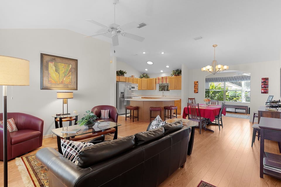 Relax in your spacious open-concept living area with comfortable leather seating, modern kitchen, and dining space perfect for memorable meals together.