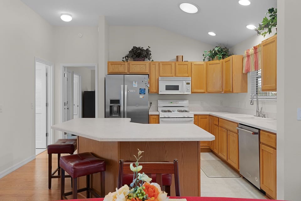Cook your favorite meals in this spacious kitchen featuring modern appliances, ample counter space, and a convenient breakfast bar.