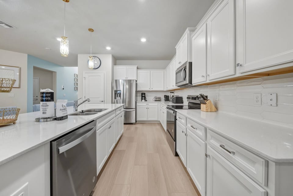 Discover a bright kitchen with white cabinetry and sleek countertops for a clean, airy feel. The stainless steel appliances offer modern convenience, ideal for preparing meals or enjoying casual breakfasts.