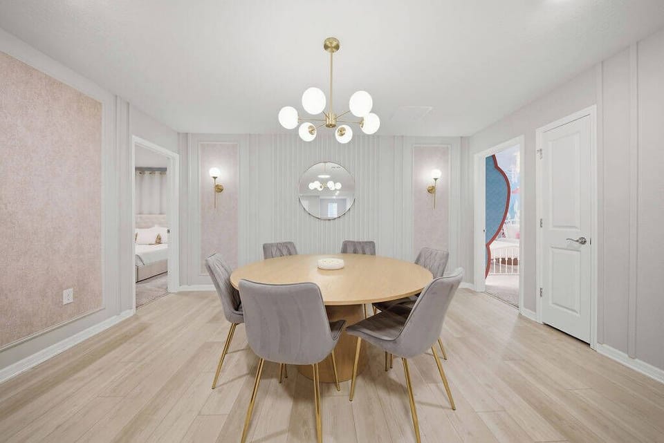 Step into a stylish entryway featuring a warm wooden console table adorned with elegant decor and a round mirror that enhances the spacious feel. Soft lighting highlights the refined gray walls, inviting you to explore further.
