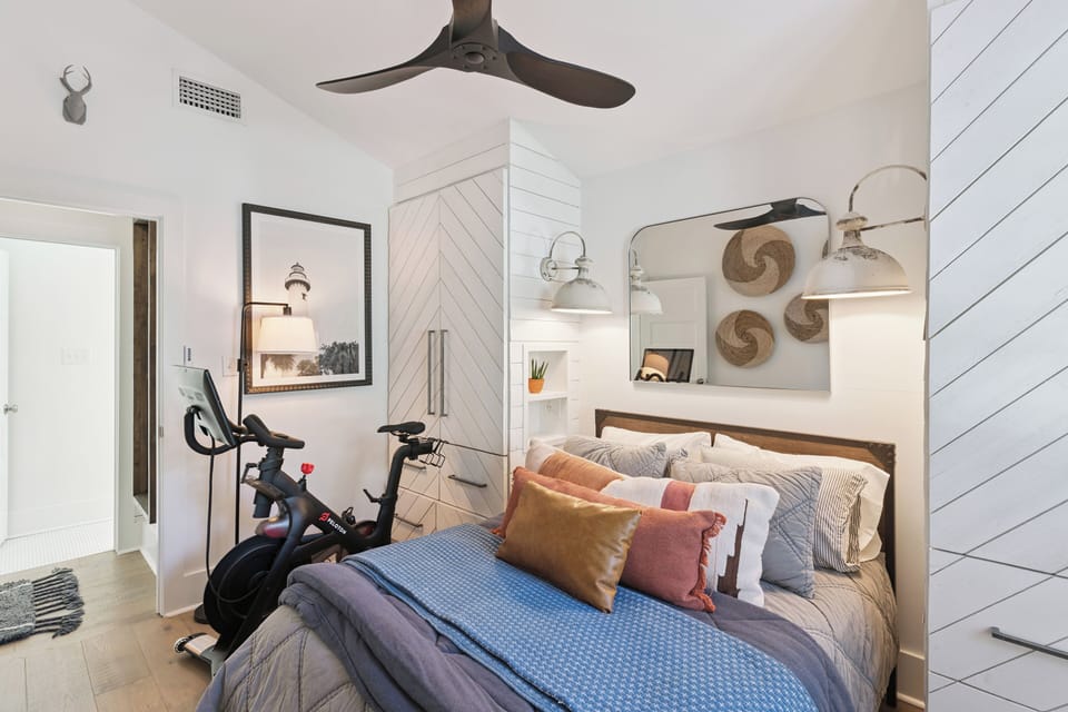 Unwind in your coastal-inspired bedroom featuring custom built-ins, nautical touches, and modern conveniences like your personal exercise bike for morning workouts.