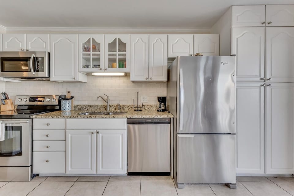 Your spacious kitchen awaits with full-size stainless steel appliances, granite countertops, and ample cabinet storage for all your culinary adventures.