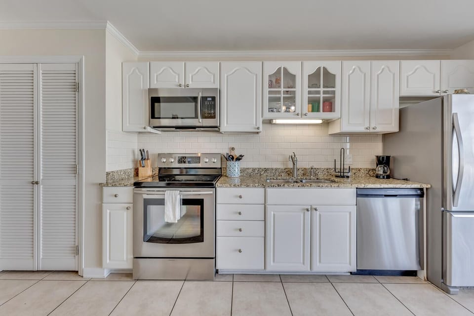 Enjoy preparing meals in this bright, fully-equipped kitchen with modern stainless steel appliances and granite countertops.