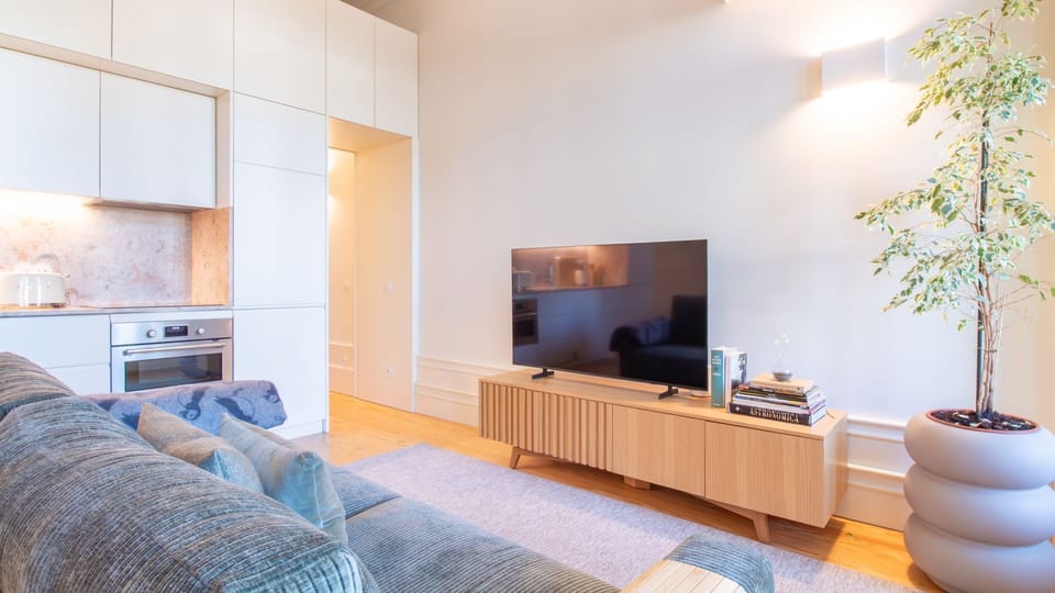 A sleek, fully equipped kitchen blends seamlessly into the living space, perfect for cozy nights in or slow mornings. #OpenPlan #MinimalDesign #PortoStay