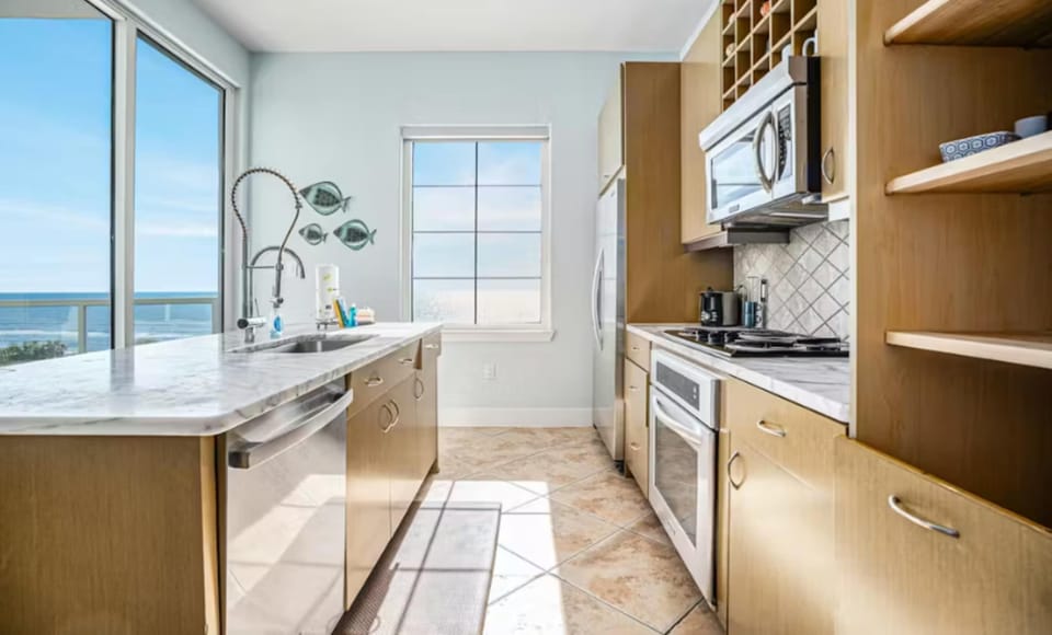 Open bright fully equipped kitchen WITH a VIEW of the ocean.