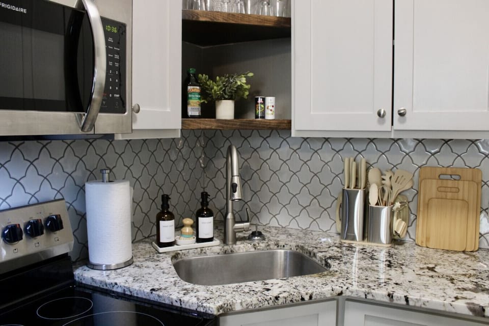 Kitchen. This space features stainless steel Frigidaire appliances, granite countertops, and a stylish tile backsplash.