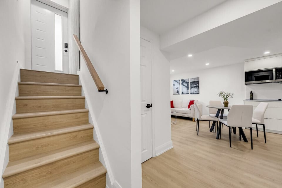 View of the light-colored wooden staircase connecting levels, creating an airy and welcoming transition within the property.