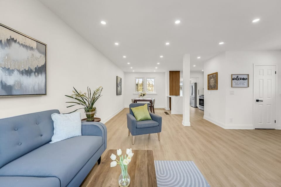Enjoy the bright and airy main floor, featuring light wood flooring and seamless flow from the living area to the dining room and kitchen.