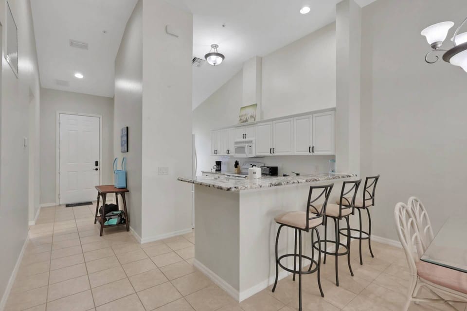 An eating bar with 3 bar stools separates the kitchen from the main living space.