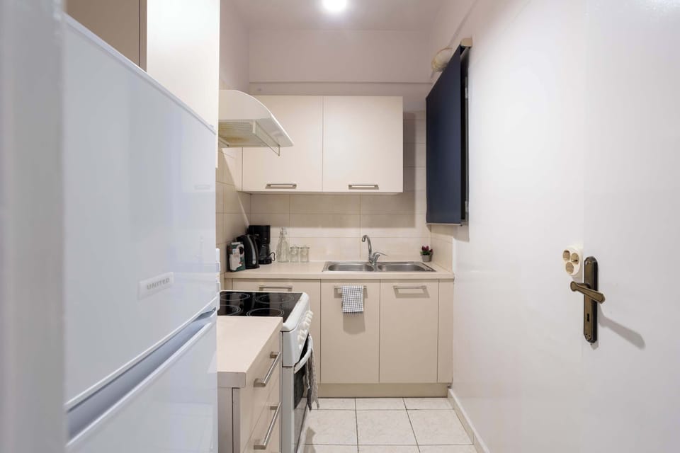 Fully equipped kitchen with stove, fridge and cookware.