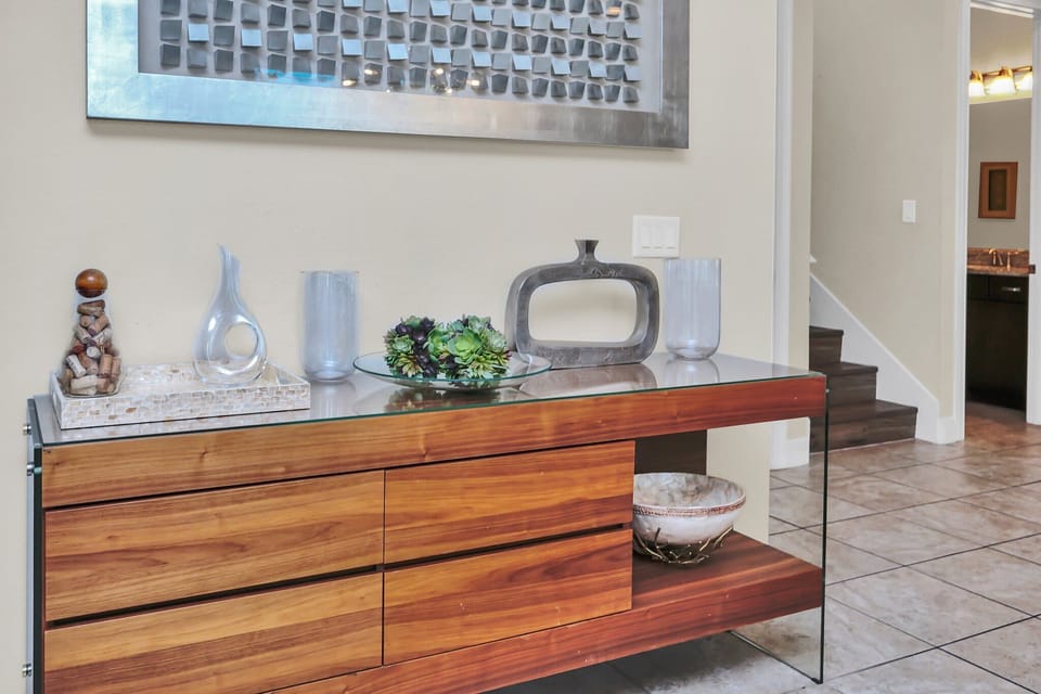 Modern wooden console table with decorative accents in a bright entryway.