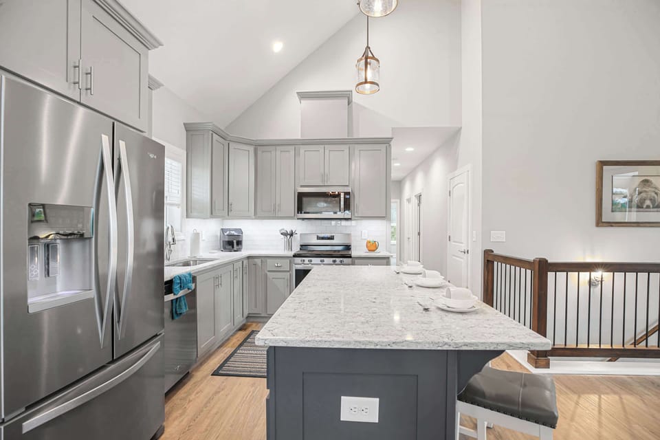 Modern kitchen with stainless steel appliances and a spacious marble island for family meals.